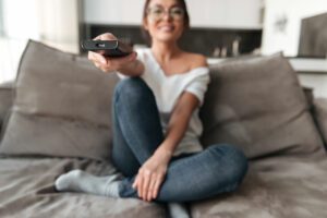 happy-young-woman-sitting-sofa-home-watch-tv